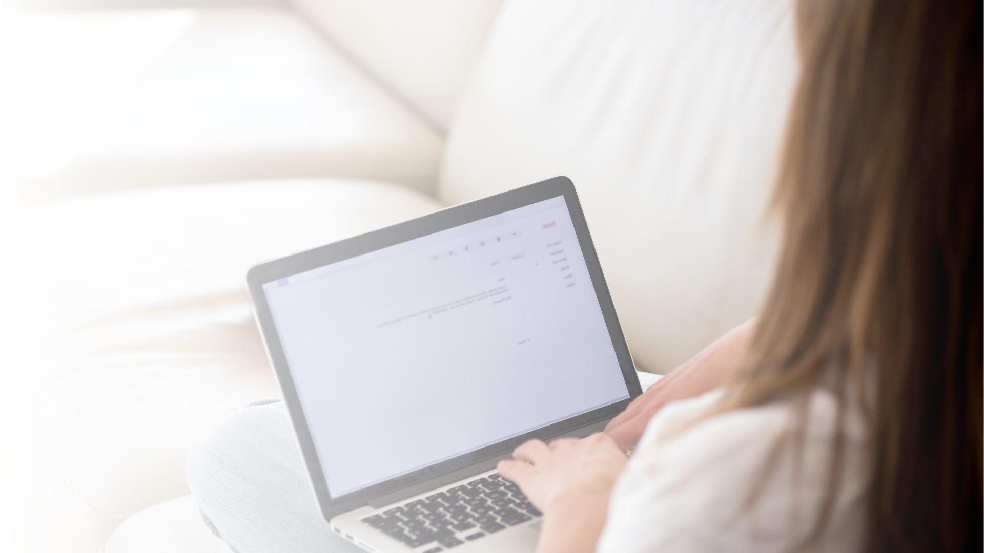 Vrouw op de bank typt een bericht op haar laptop